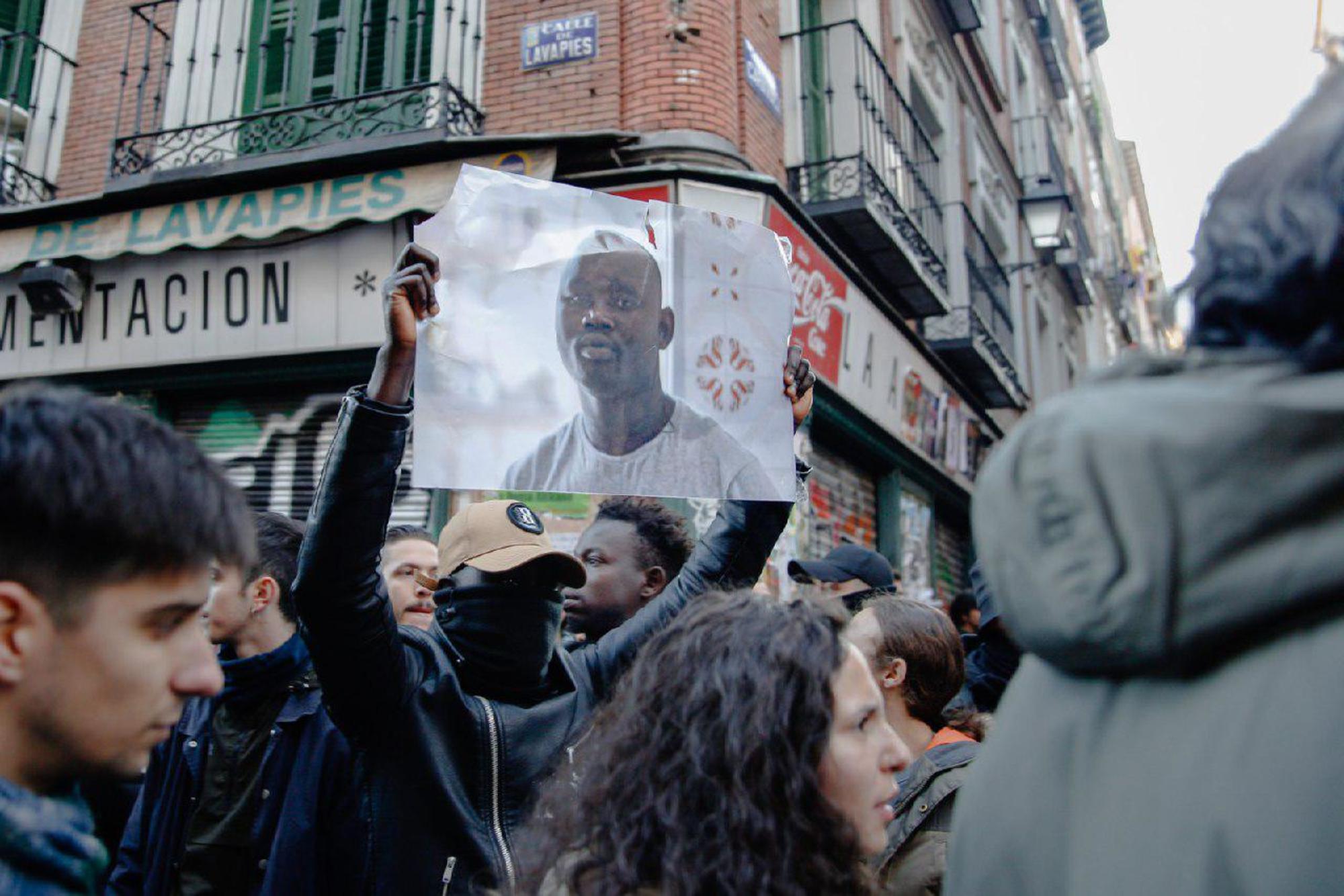 Un manifestante sostiene el retrato de Mame Mbaye en la manifestación del 16 de marzo de 2018.